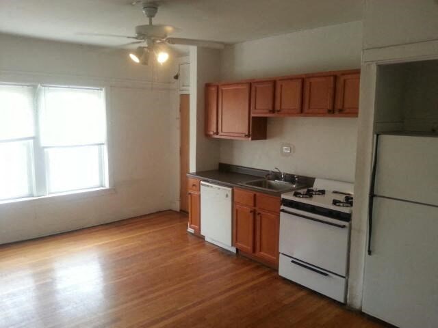an empty kitchen with a stove and a refrigerator