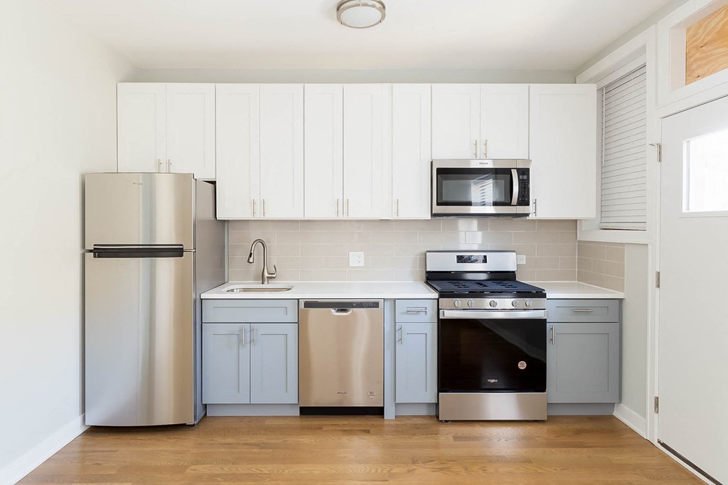 a kitchen with white cabinets and stainless steel appliances