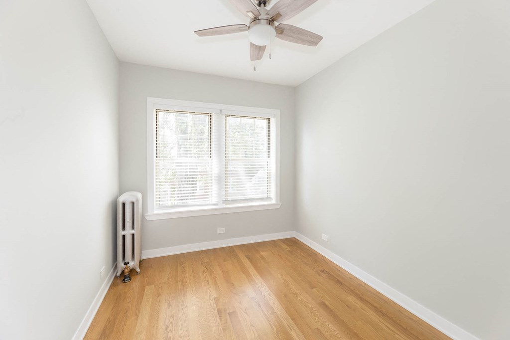 an empty room with a ceiling fan and a window