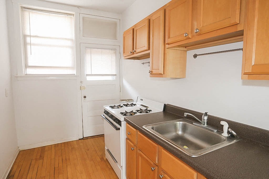 a kitchen with a sink and a stove and a door