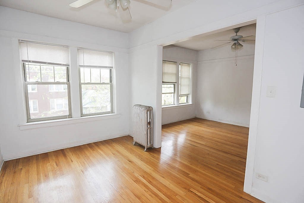 an empty room with wood floors and a radiator