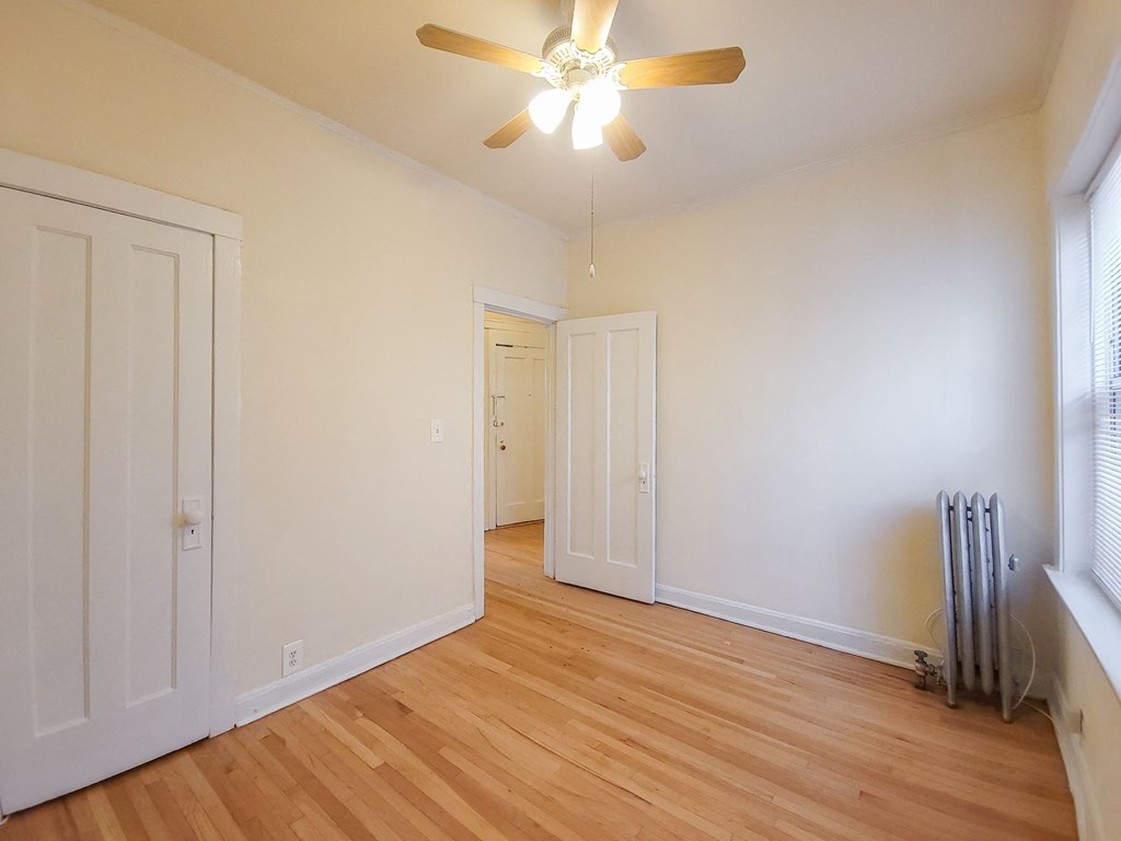a living room with white walls and a ceiling fan