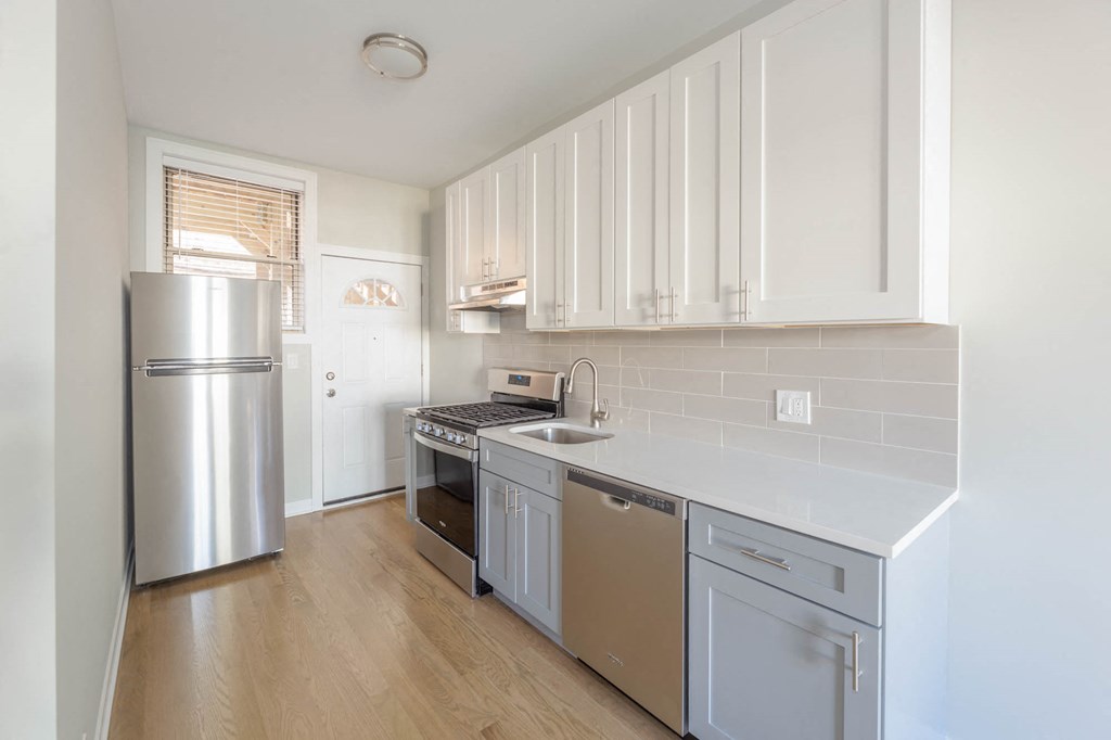 a kitchen with stainless steel appliances and white cabinets