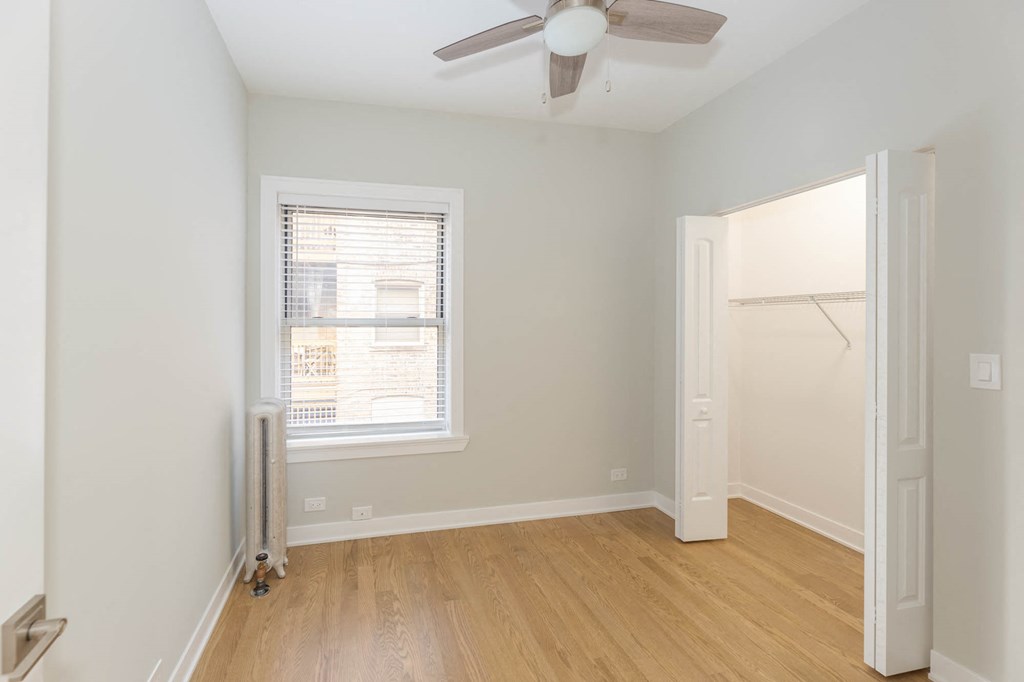 a bedroom with a ceiling fan and a window