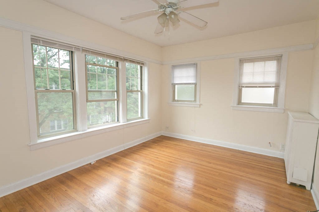 a living room with a wood floor and a ceiling fan