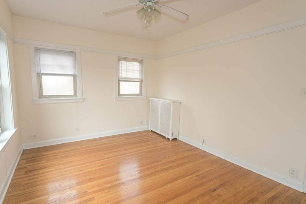 a living room with a hard wood floor and a ceiling fan