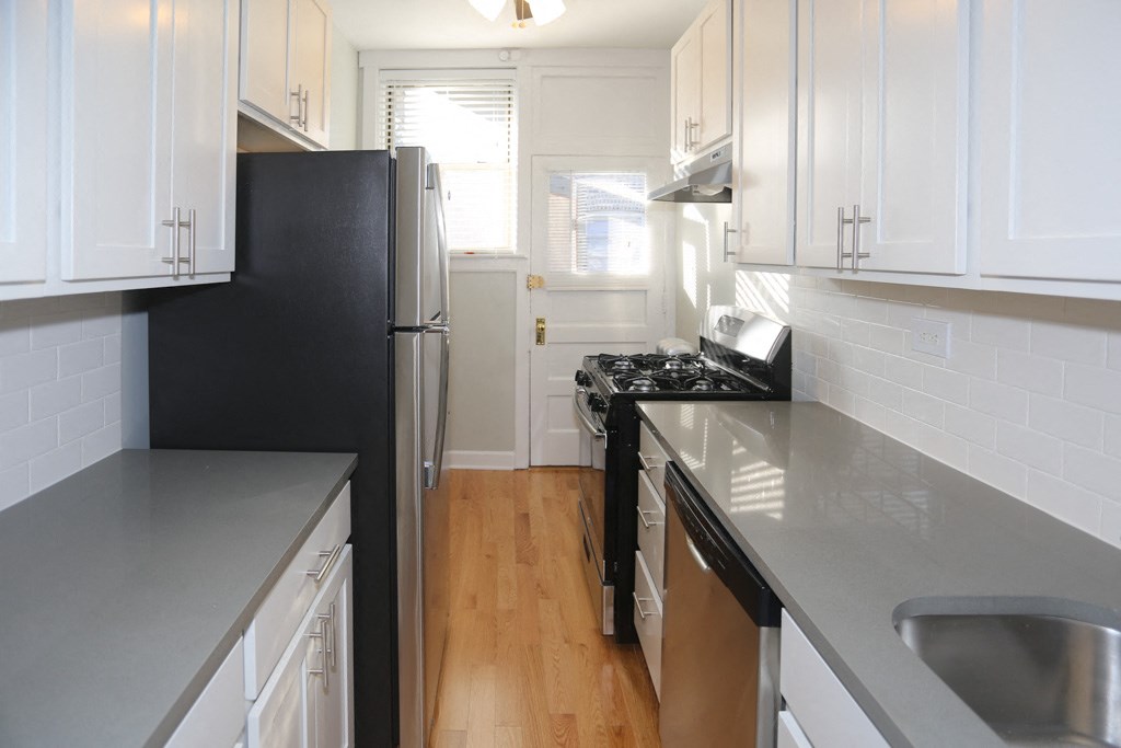 a kitchen with black appliances and white cabinets