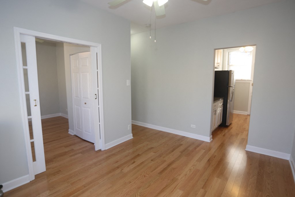 a living room with wood floors and a door to a bedroom