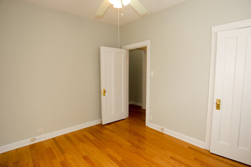 a bedroom with wood floors and a closet
