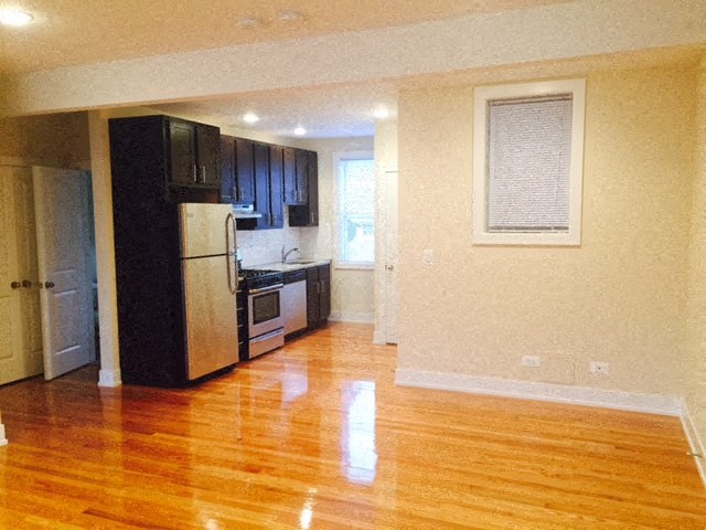 a kitchen with a wood floor and a refrigerator