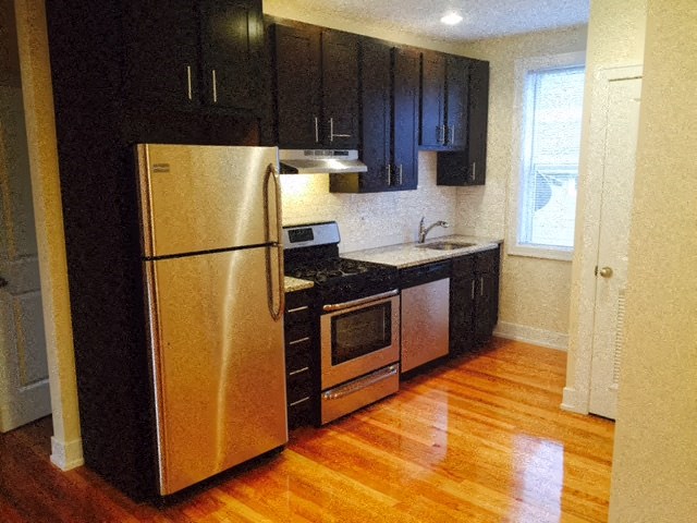a kitchen with a stainless steel refrigerator