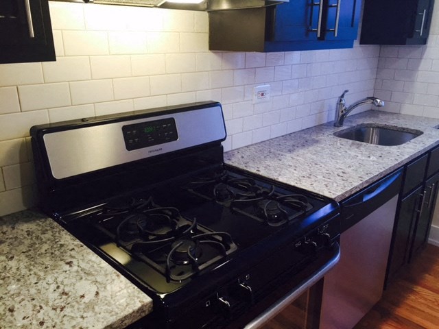 a black stove in a kitchen next to a sink