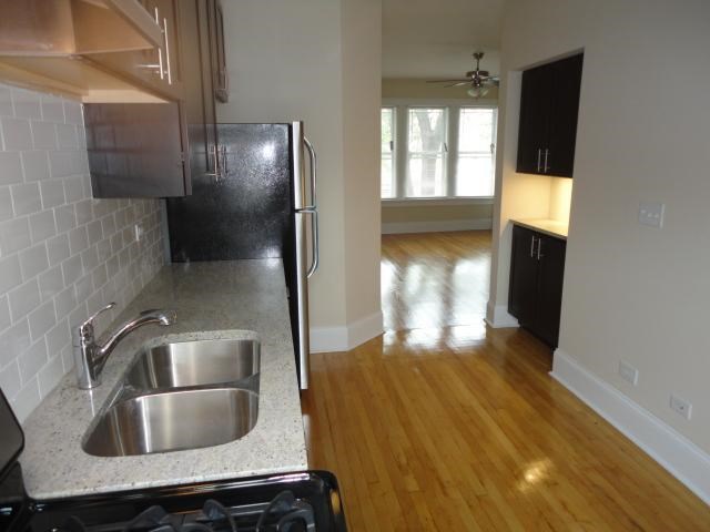 an empty kitchen with a sink and a refrigerator