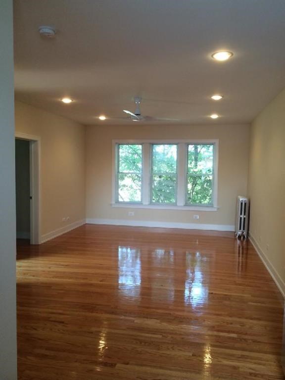 an empty living room with a wood floor and a window