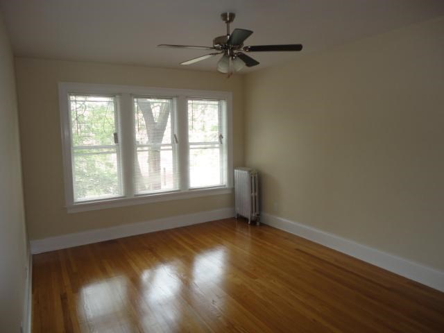 an empty room with a ceiling fan and a window