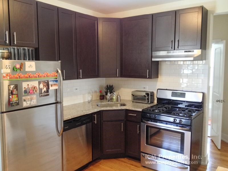a kitchen with stainless steel appliances and wooden cabinets