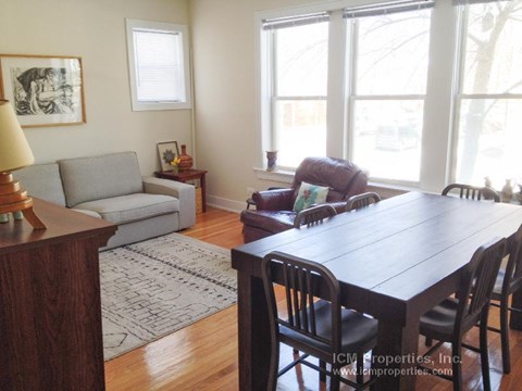 a living room with a wooden table and chairs
