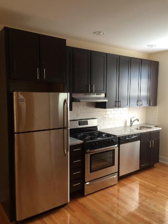 a kitchen with stainless steel appliances and black cabinets
