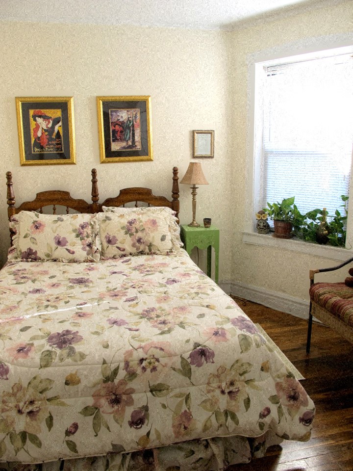a bedroom with a bed and two pictures on the wall