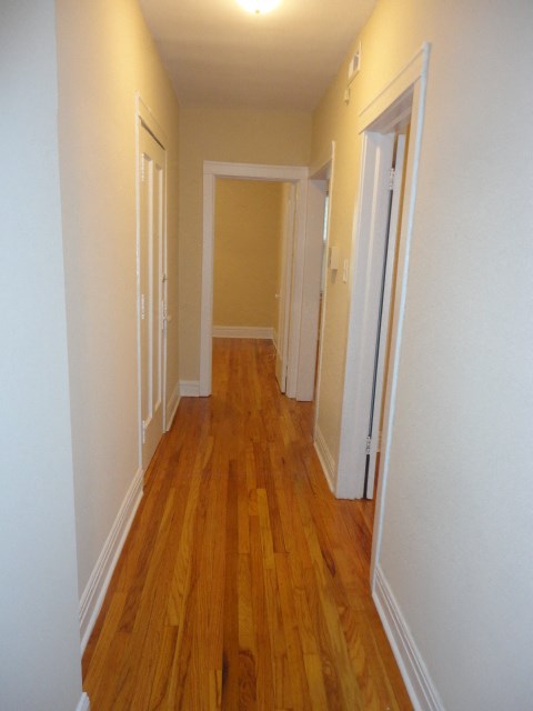 a living room and hallway with wood floors and white walls