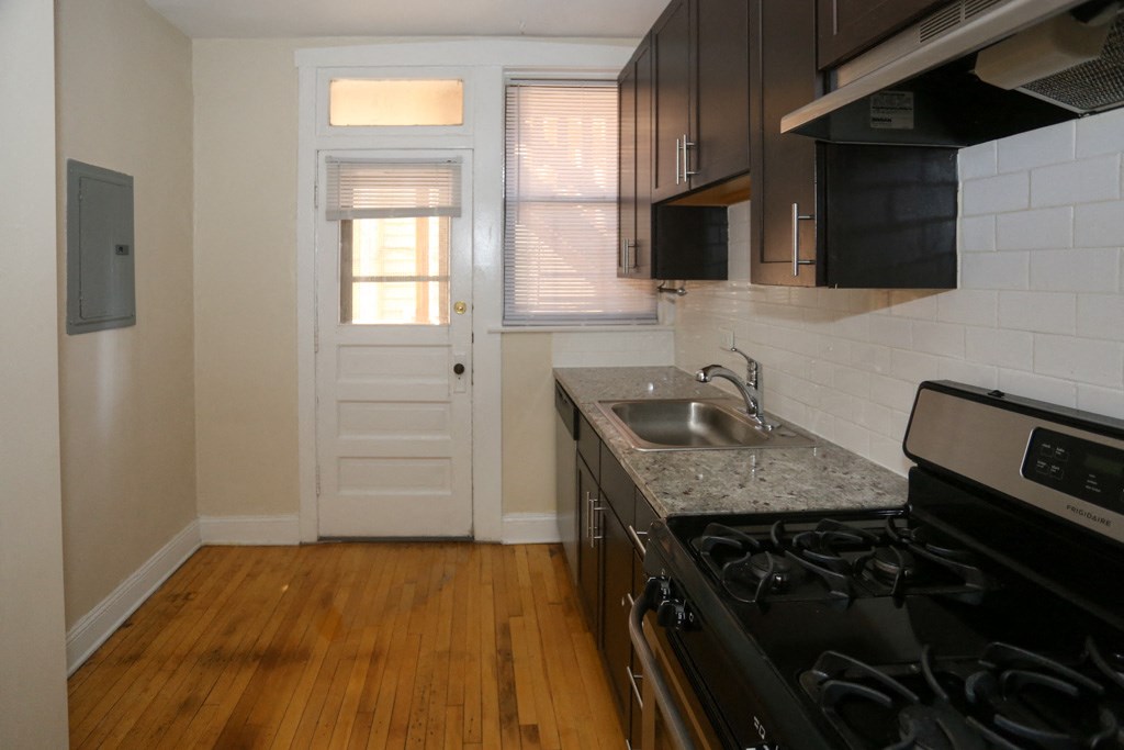 a kitchen with a stove and a sink and a door