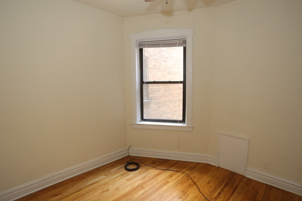 an empty room with a window and a fan in it