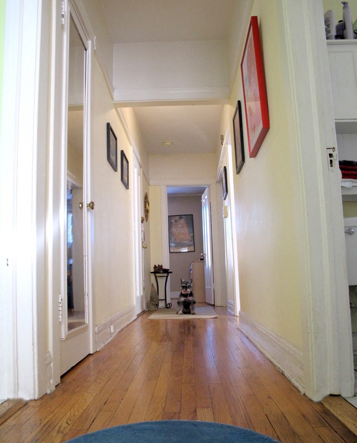 a hallway with a hard wood floor and white walls