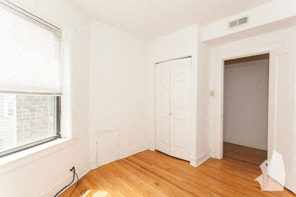 an empty room with a window and a door