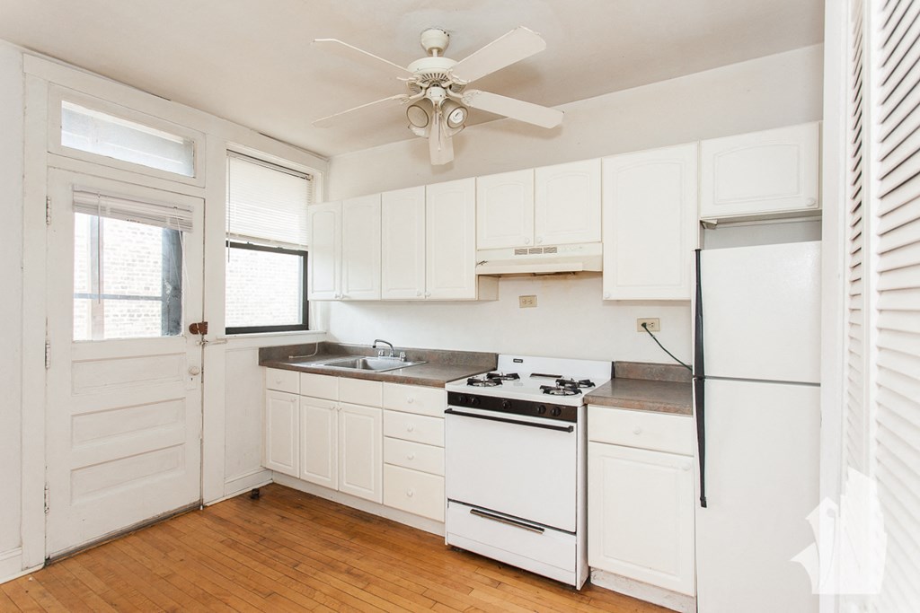 a kitchen with white cabinets and a white refrigerator