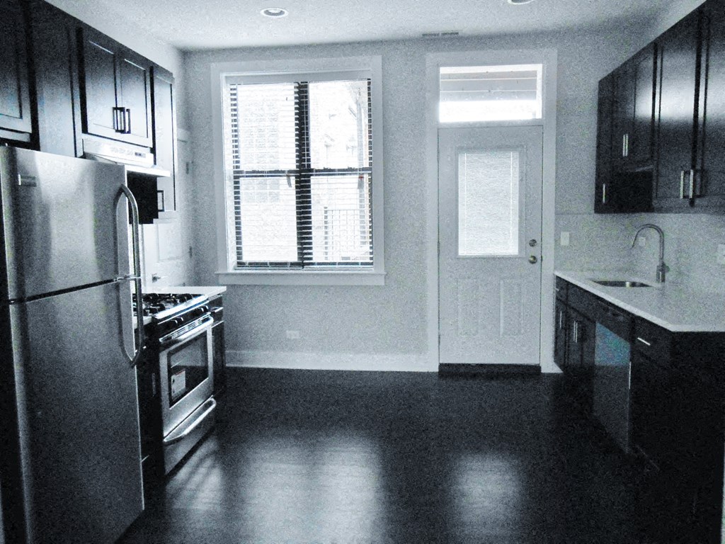a kitchen with a stove and a refrigerator and a window