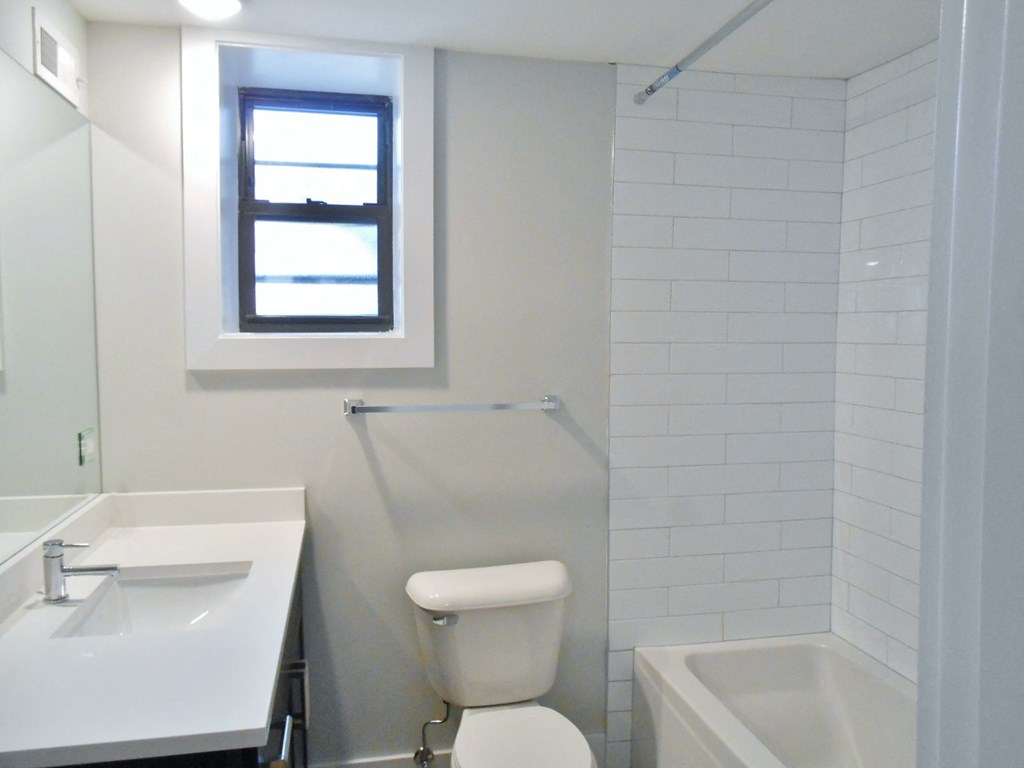 a bathroom with a toilet and a sink and a window