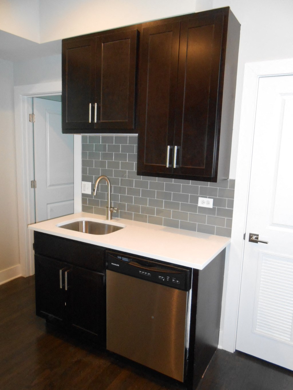 a small kitchen with a sink and cabinets and a door