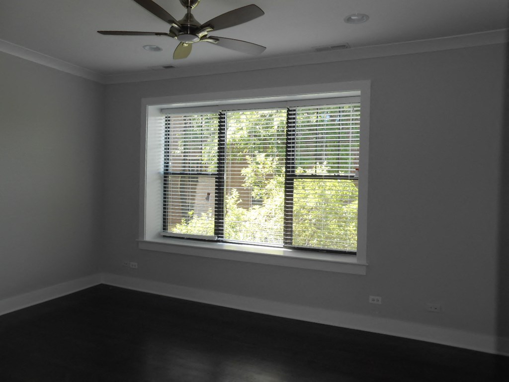 a large window in a room with a ceiling fan