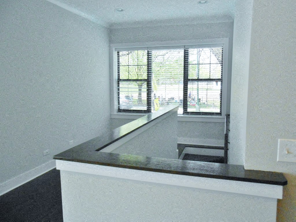 an empty kitchen with a counter top and a window