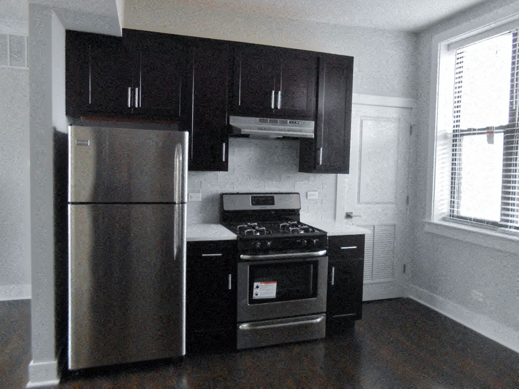 a kitchen with stainless steel appliances and black cabinets