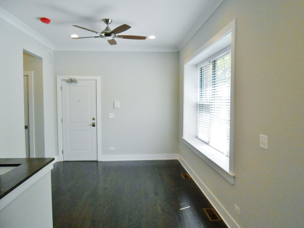 an empty room with a window and a ceiling fan