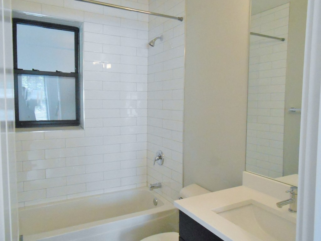 a bathroom with a tub and a sink and a toilet