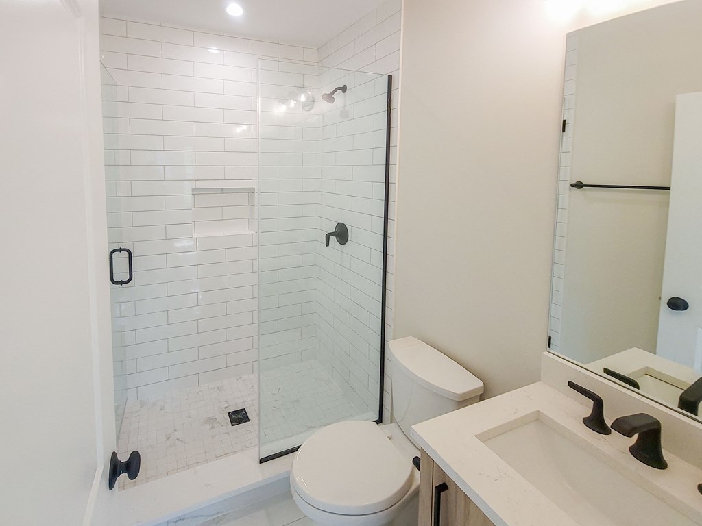 a bathroom with a shower and a sink and a toilet