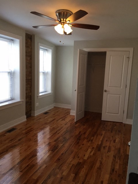 a living room with a wooden floor and a ceiling fan