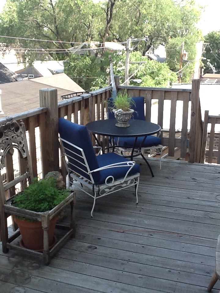a patio with a table and chairs on a wooden deck