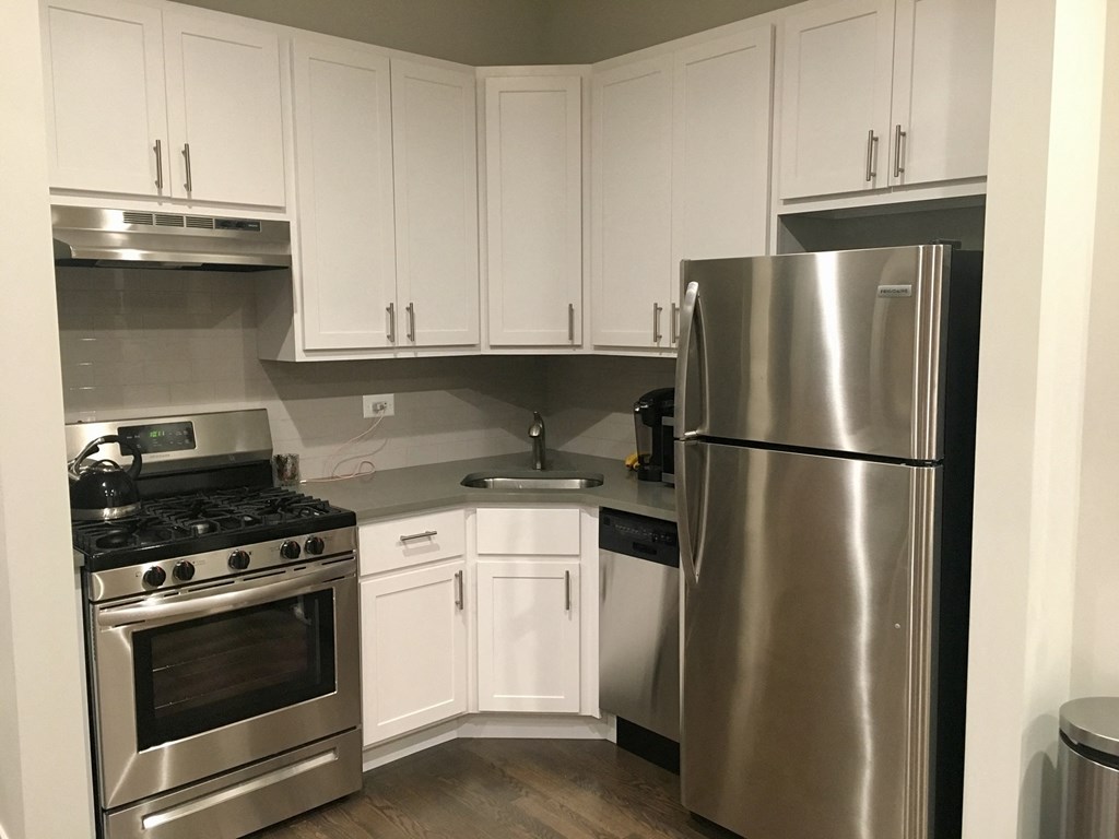 a kitchen with stainless steel appliances and white cabinets