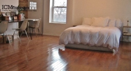 a bedroom with a bed and a hard wood floor