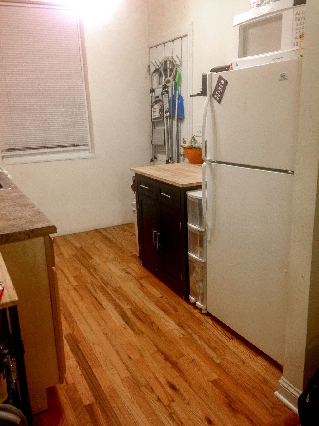a kitchen with a refrigerator and wooden floors