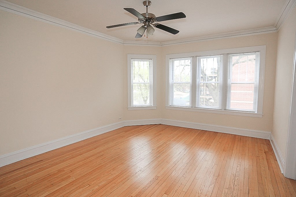 an empty room with wooden floors and a ceiling fan
