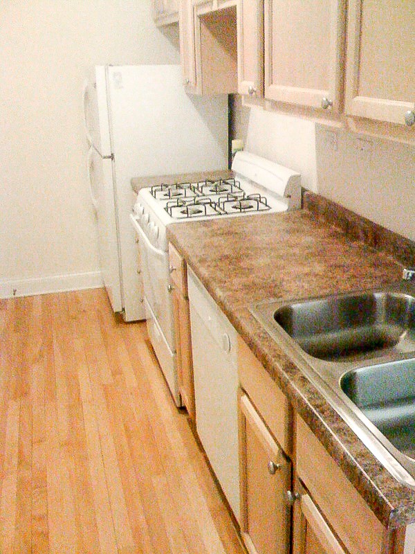 a kitchen with a stove and a sink and a refrigerator