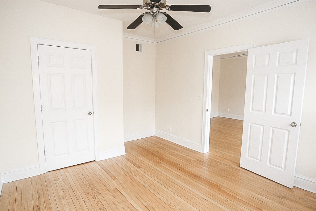 an empty room with two doors and a ceiling fan