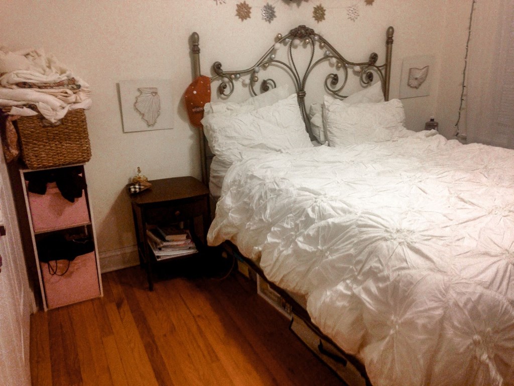 a bedroom with a bed and a wooden floor