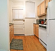 a kitchen with a white refrigerator and a door
