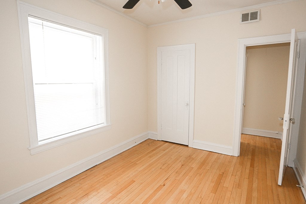 an empty room with wooden floors and a window and a closet