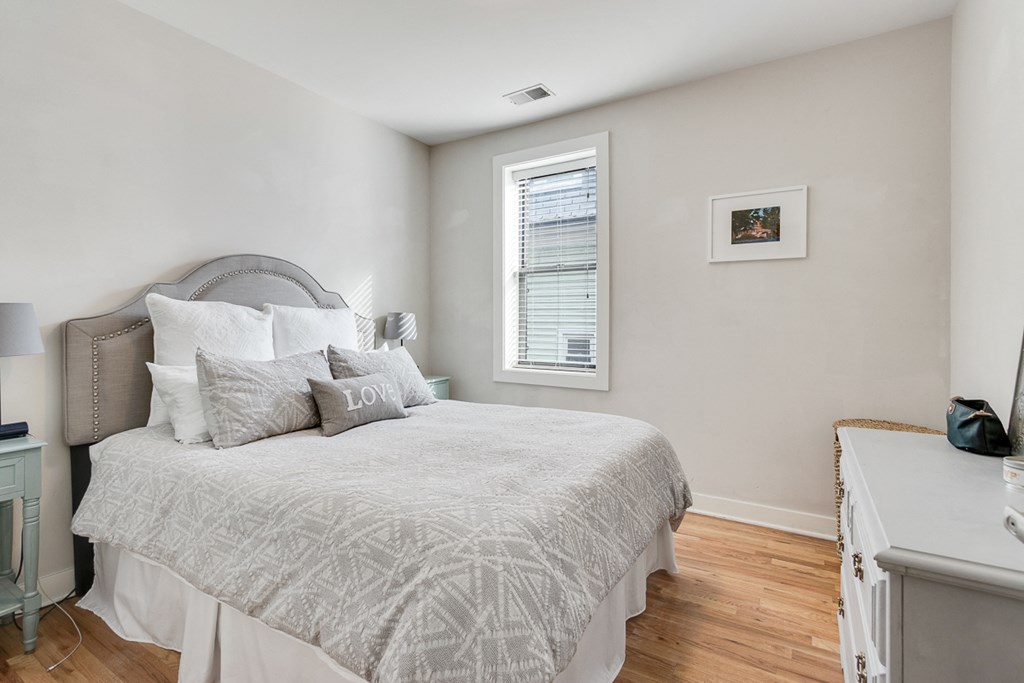 a bedroom with a bed and a desk and a window